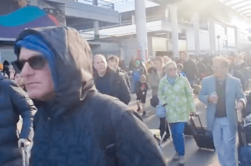 a man in a hooded jacket is walking through a crowd of people