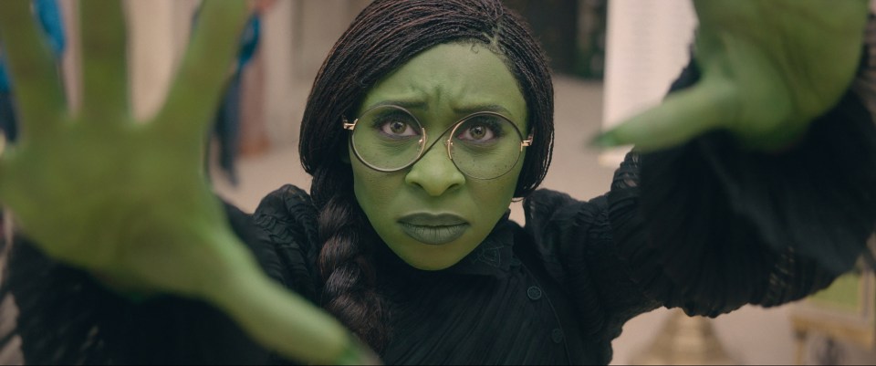 a woman with green paint on her face and glasses