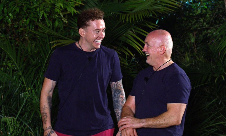 two men are standing next to each other and smiling