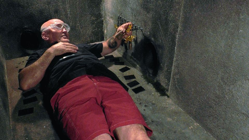 a man in a black shirt and red shorts is laying on the floor