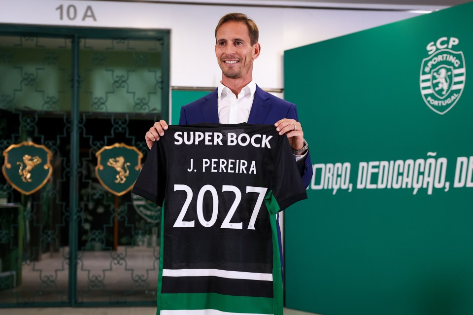 a man in a suit holds up a shirt that says super bock j. pereira 2027
