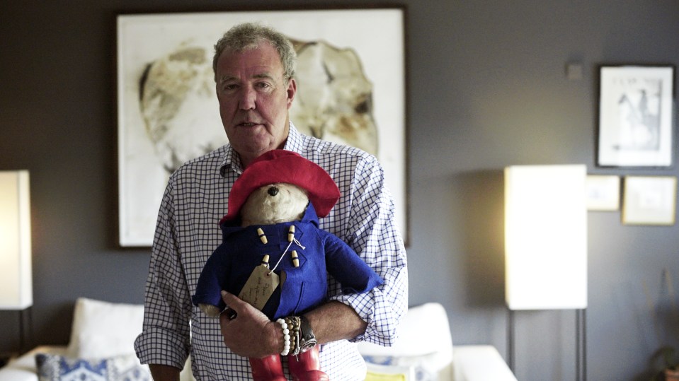 a man in a plaid shirt holds a paddington bear