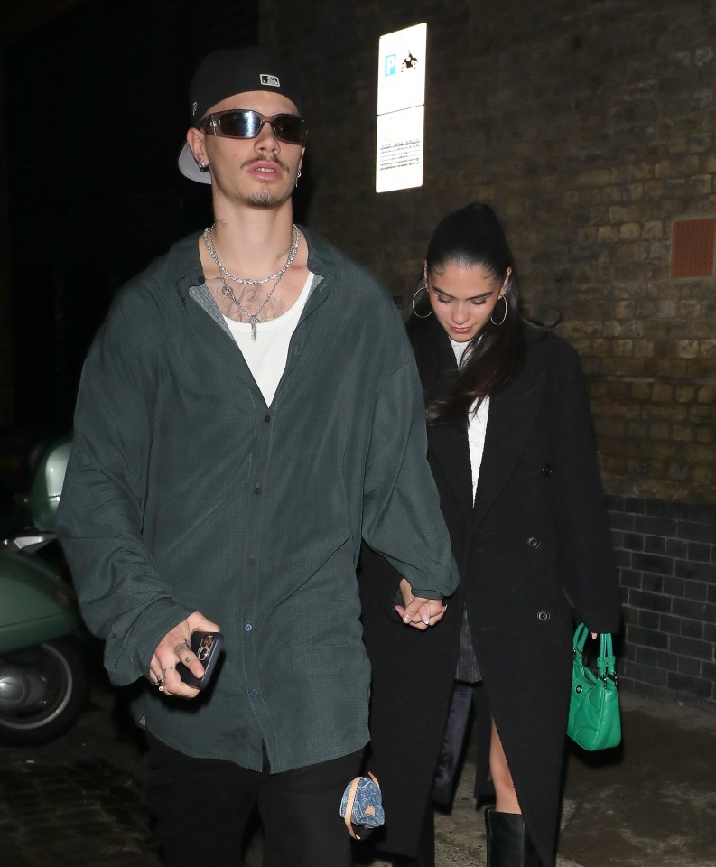 a man wearing a new york yankees hat holds hands with a woman