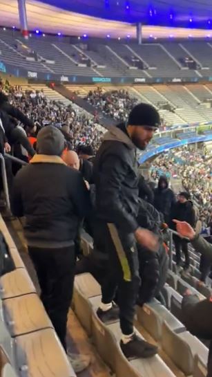 a man is standing in the stands of a stadium .