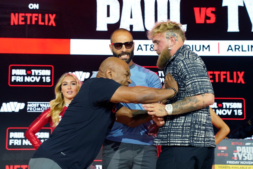 two men standing in front of a sign that says paul vs tyson