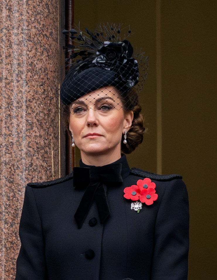 a woman wearing a black hat and a red poppy pin