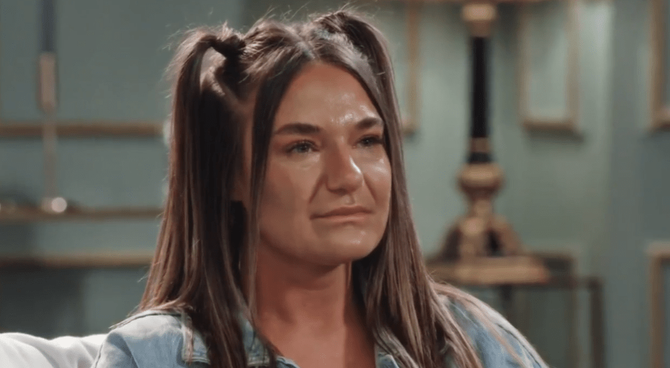 a woman with pigtails is sitting on a couch and crying