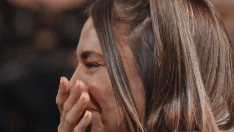 a close up of a woman covering her face with her hand