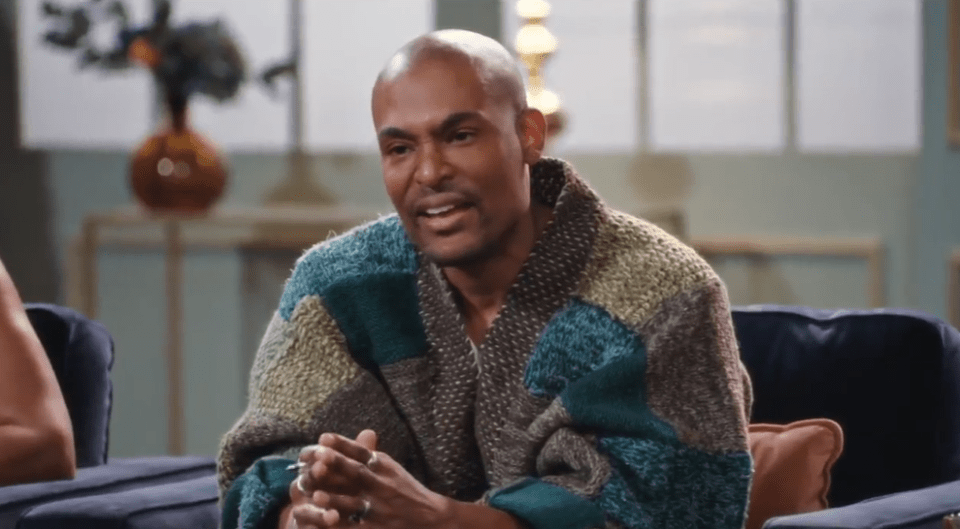 a man in a sweater is sitting on a couch