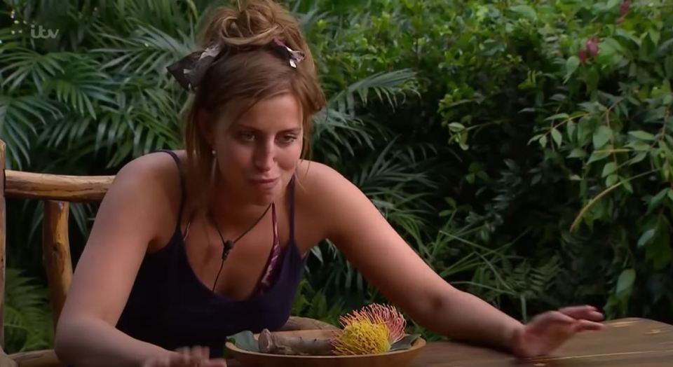 a woman sits at a table with a bowl of food in front of her and a tv screen behind her that says itv