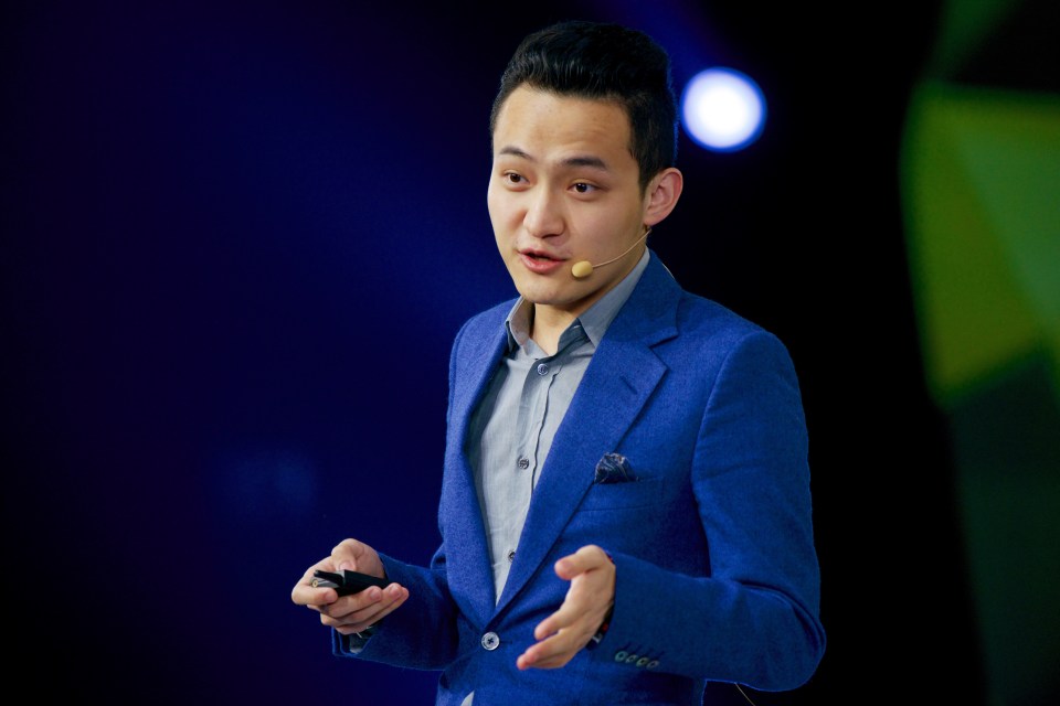 a man in a blue suit is speaking into a microphone
