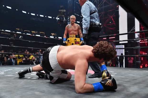a man in boxing shorts that say paul is laying on the floor