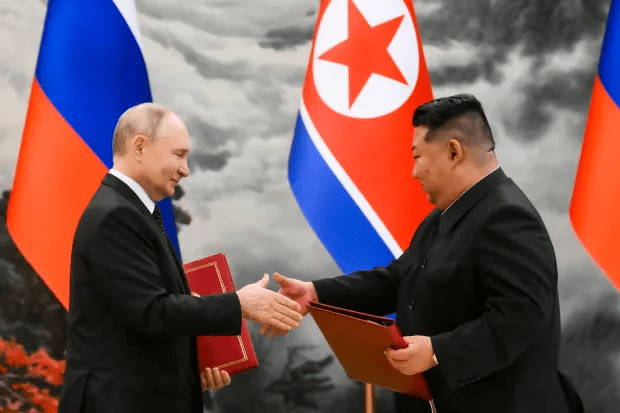 two men shaking hands in front of a flag with a red star