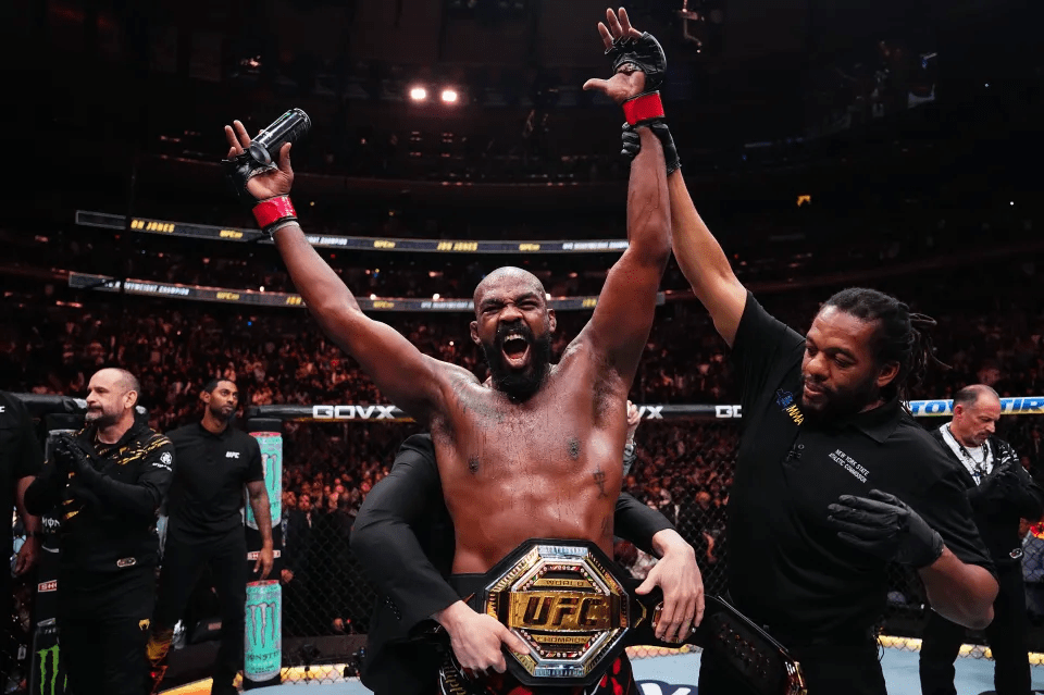 a man is holding up his ufc championship belt
