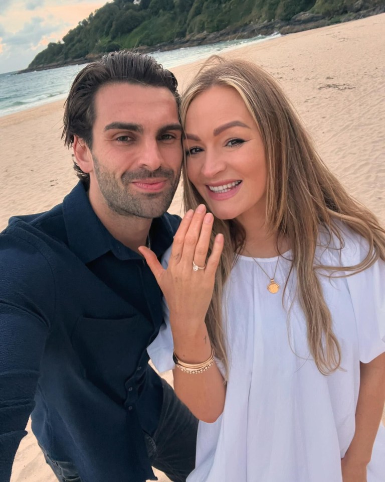 a man and a woman are posing for a picture on the beach