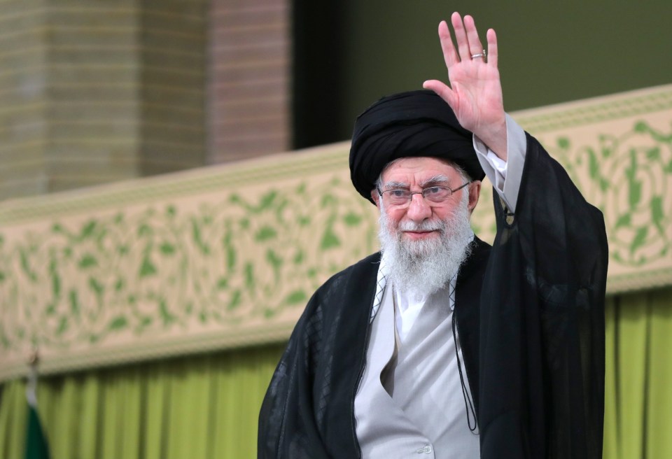 a man with a beard and glasses is waving his hand