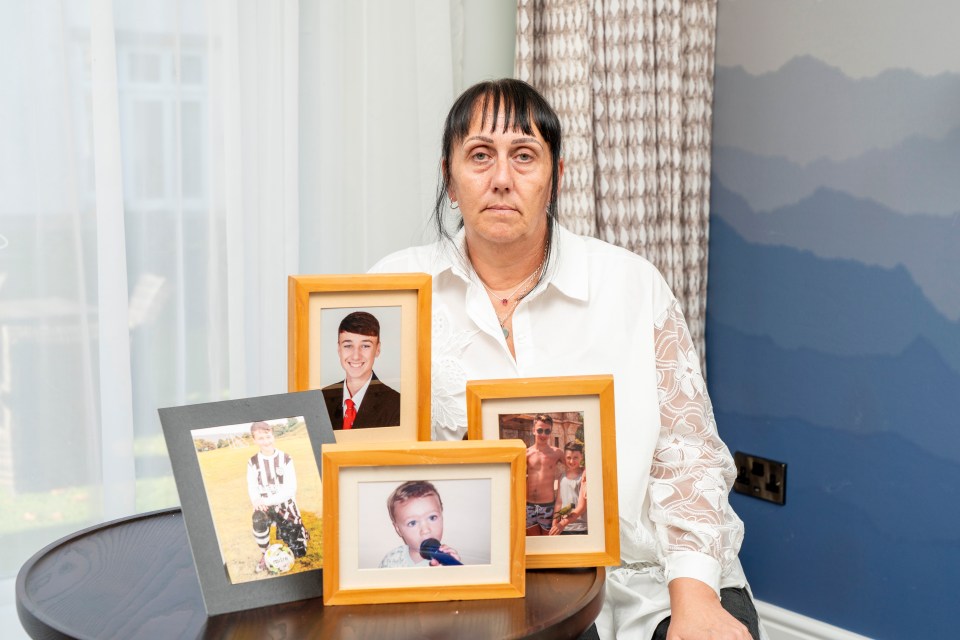 A woman sits with framed photos of her deceased son and his brother.