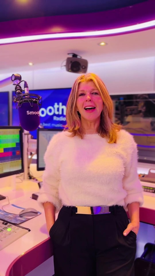 a woman stands in front of a smooth radio microphone