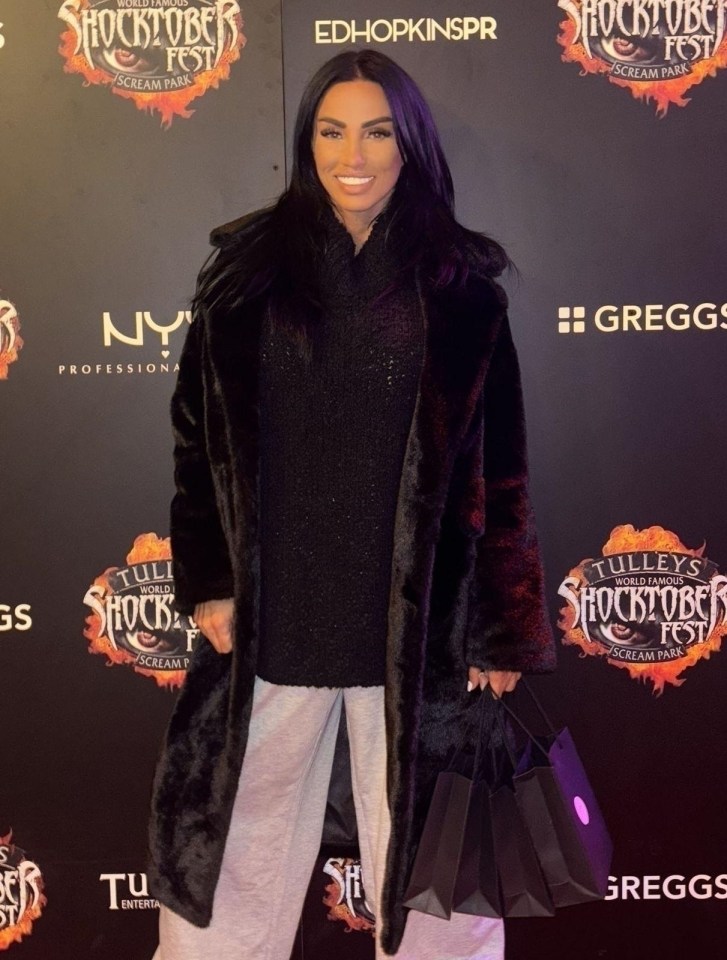 a woman stands in front of a wall that says shocktober fest