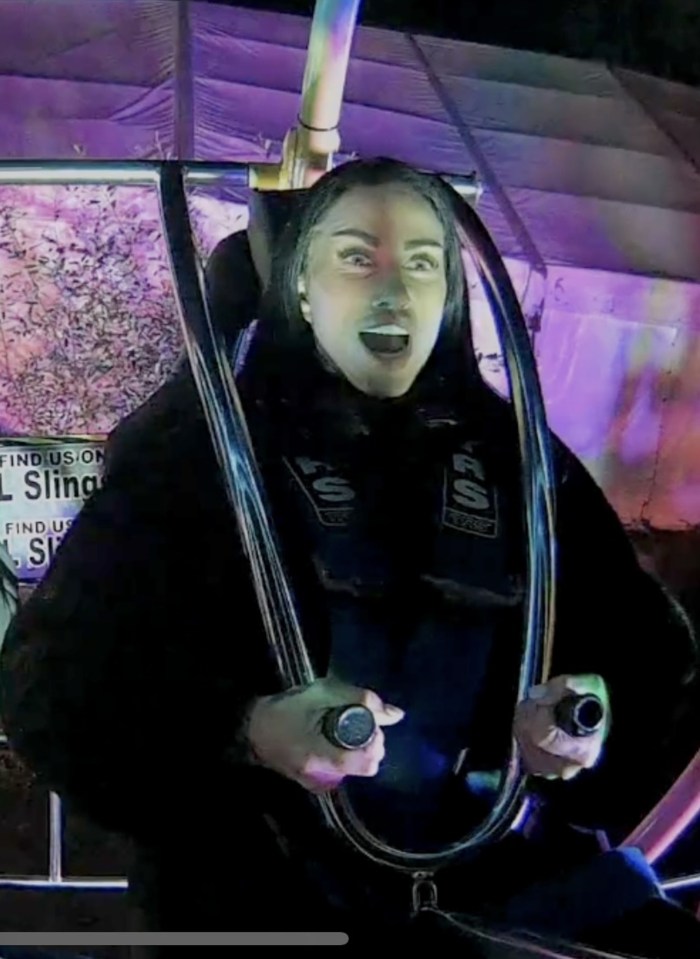 a woman is riding a sling with a sign that says find us on it