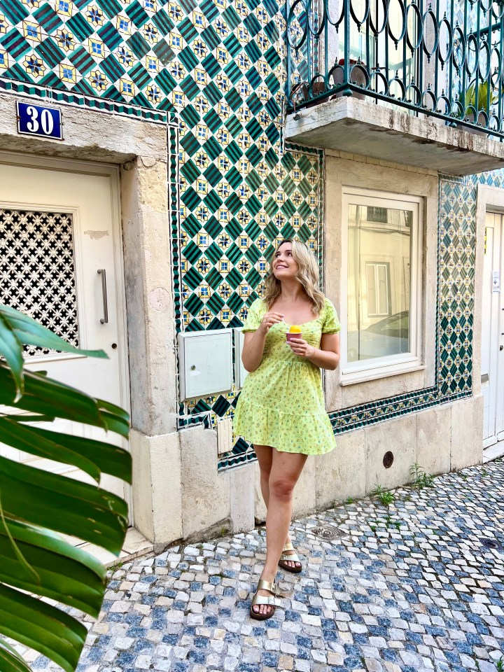 a woman stands in front of a building with the number 30 on it