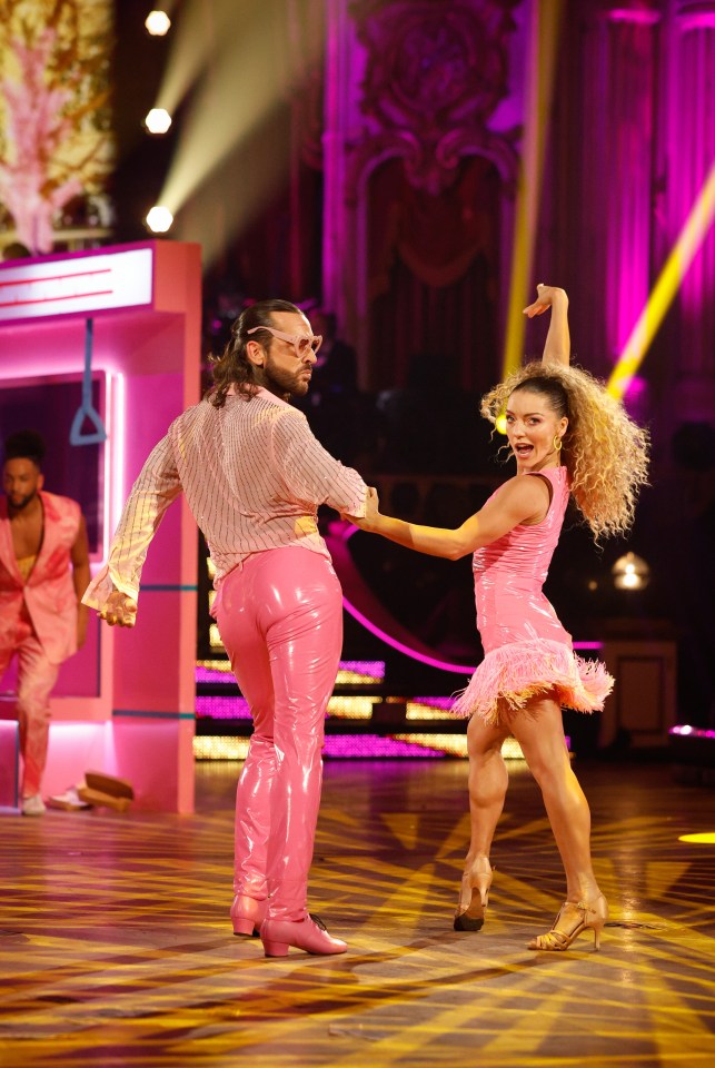 a man in pink pants is dancing with a woman in a pink dress