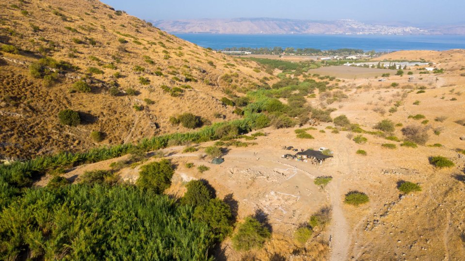 an aerial view of a desert landscape with a lake in the background