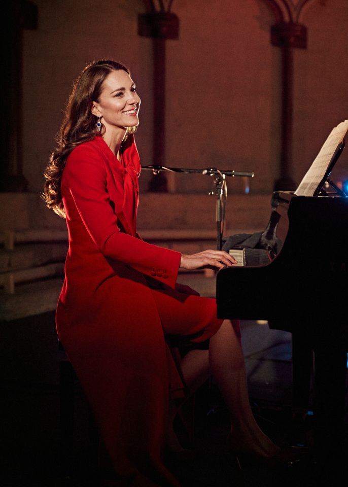 a woman in a red dress is playing a piano