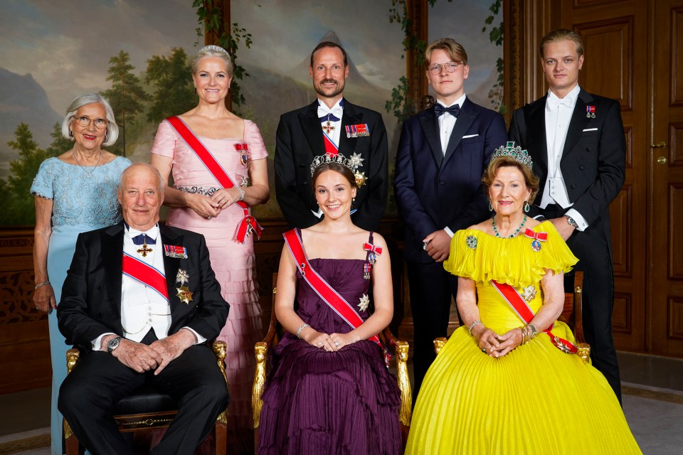 a group of people posing for a picture with one wearing a yellow dress