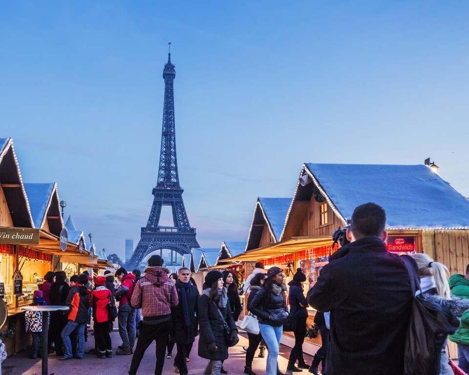 the eiffel tower is visible in the background of a christmas market