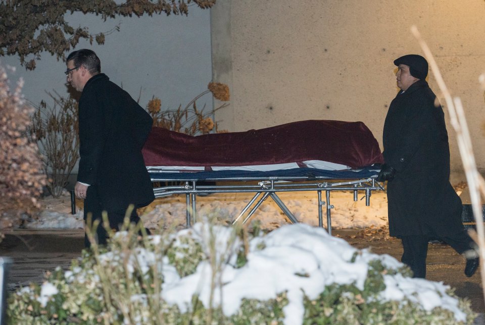 two men are carrying a coffin on a stretcher