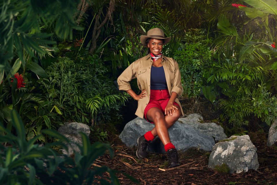 a tv screen shows a woman standing in a jungle with itv 1 on the bottom right