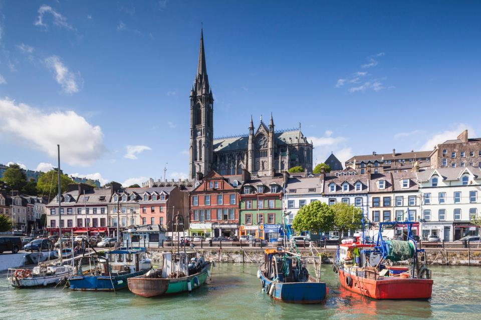 a row of boats are docked in a harbor with a church in the background