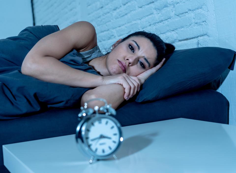 Woman lying in bed awake at night.
