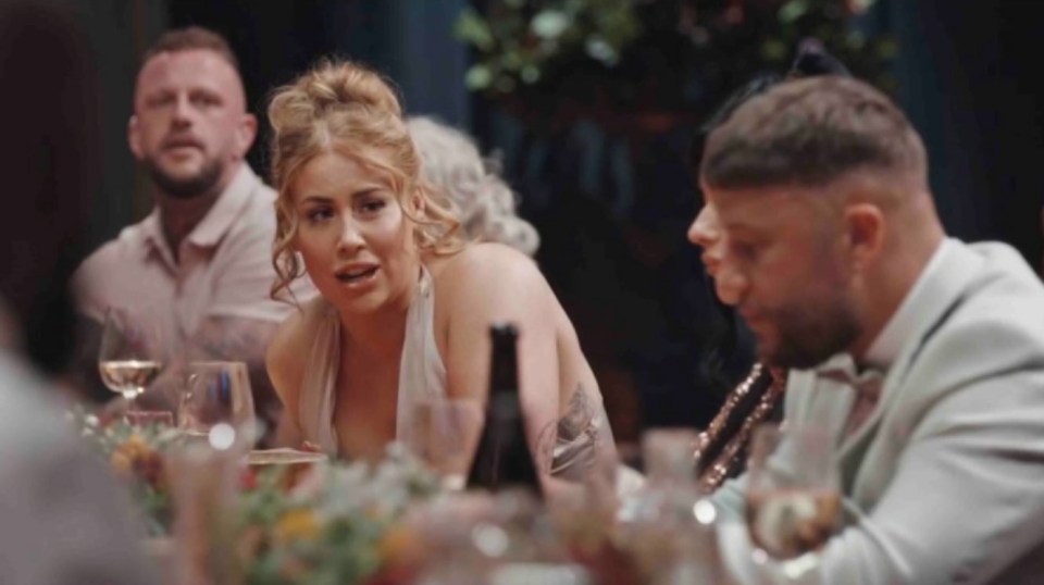 a group of people are sitting at a table with glasses of wine .