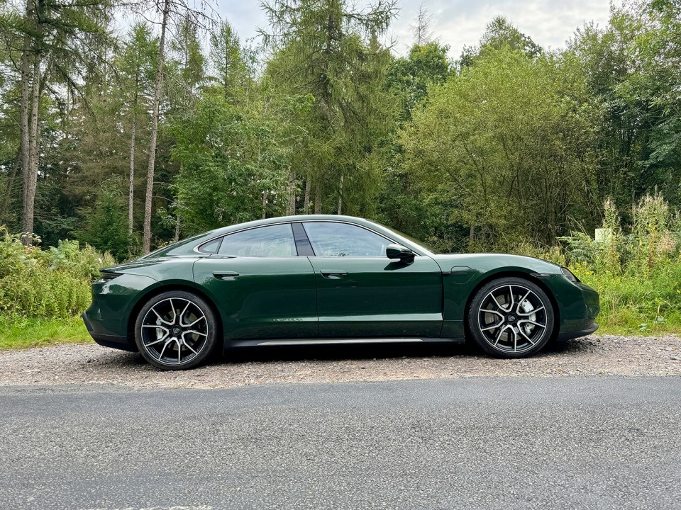 a green porsche is parked on the side of the road
