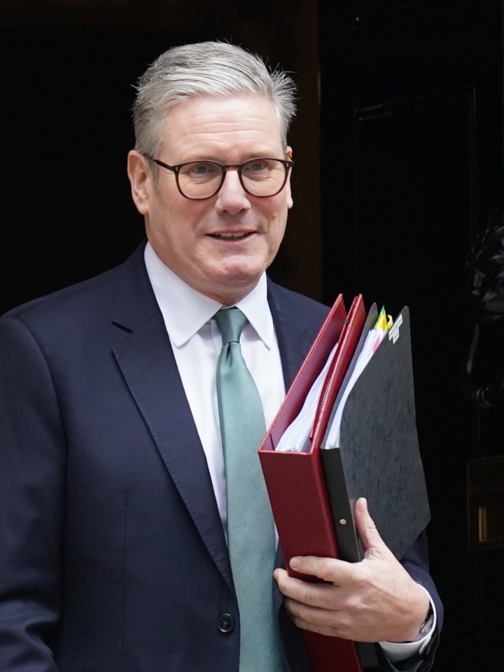 a man in a suit and tie is holding a red folder