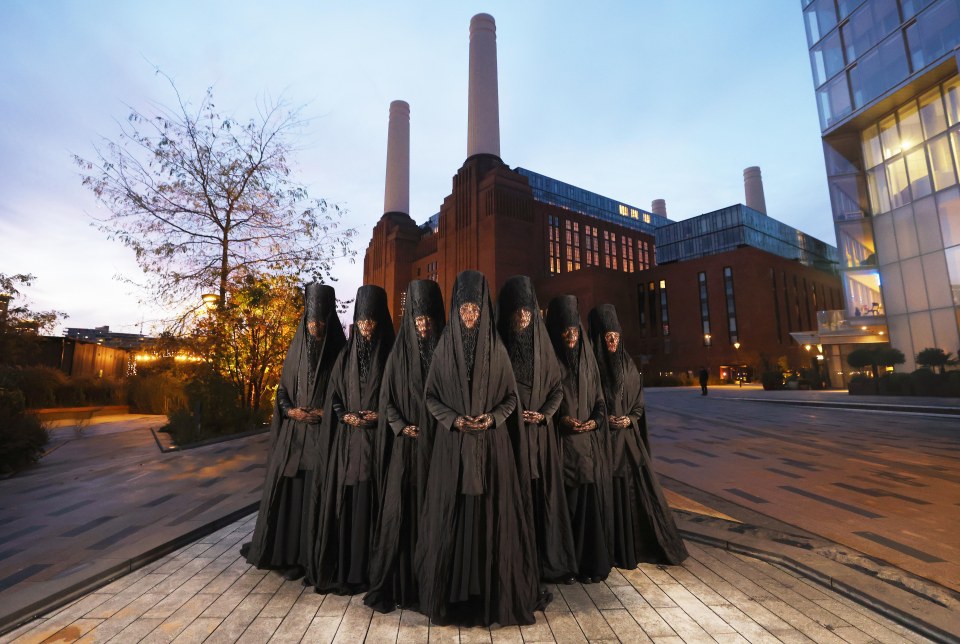 a group of people standing in front of a brick building