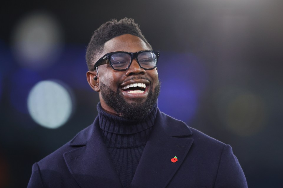a man with glasses and a poppy pin on his jacket