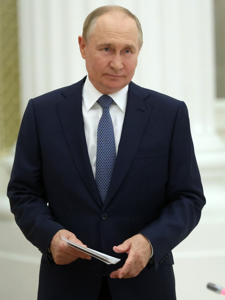 a man in a suit and tie holds a piece of paper