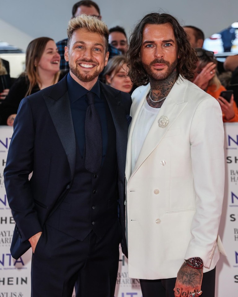 two men are standing next to each other on a red carpet that says hein on it