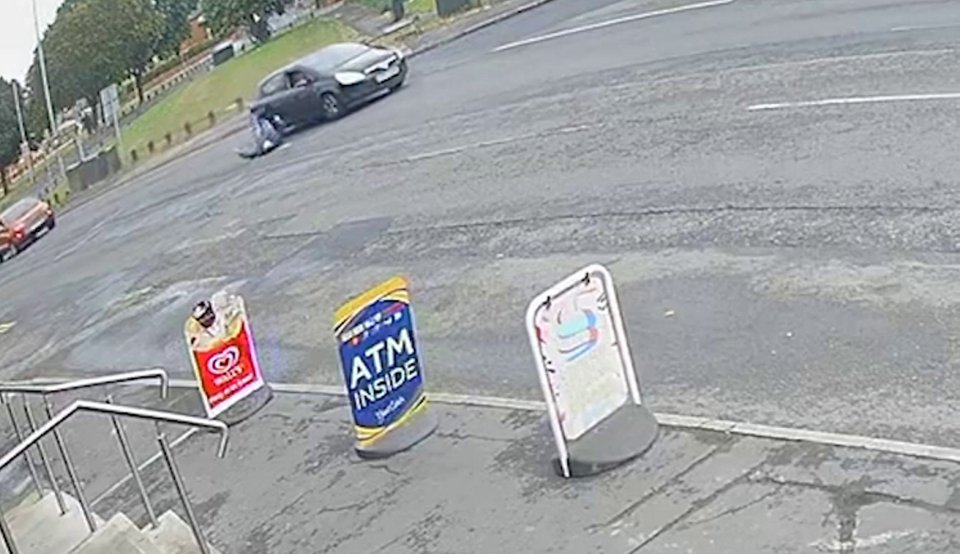a car is driving down a street next to a sign that says atm inside .