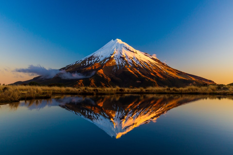 a mountain is reflected in a body of water