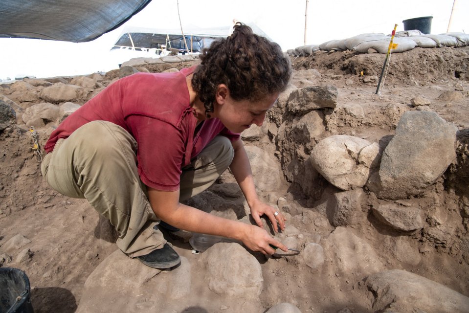 a woman in a red shirt is digging in the dirt