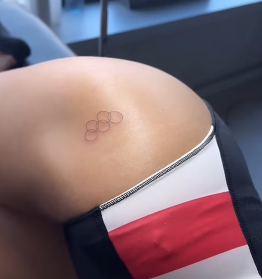 a woman has a tattoo of the olympic rings on her back