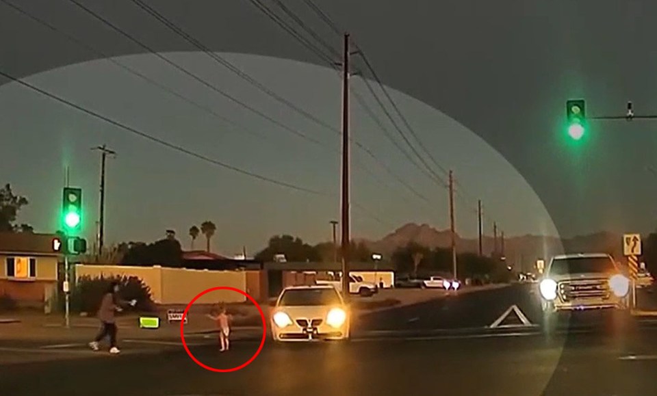 a child is crossing the street at a green light