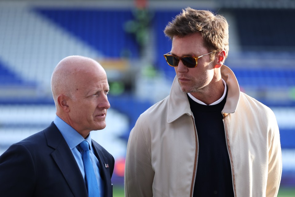 two men standing next to each other with one wearing sunglasses