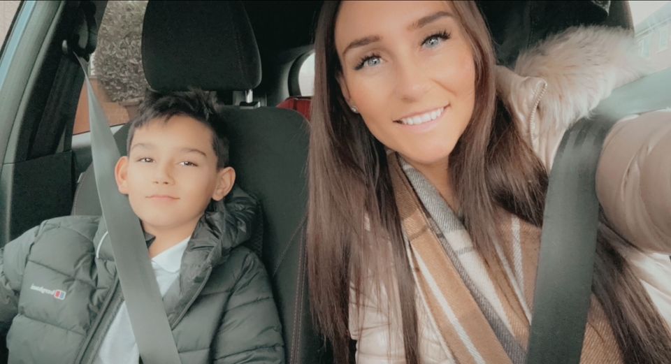 a woman and a boy are sitting in the back seat of a car