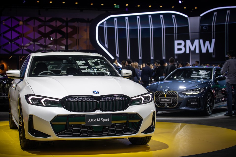 a white bmw 330e m sport is on display at a car show