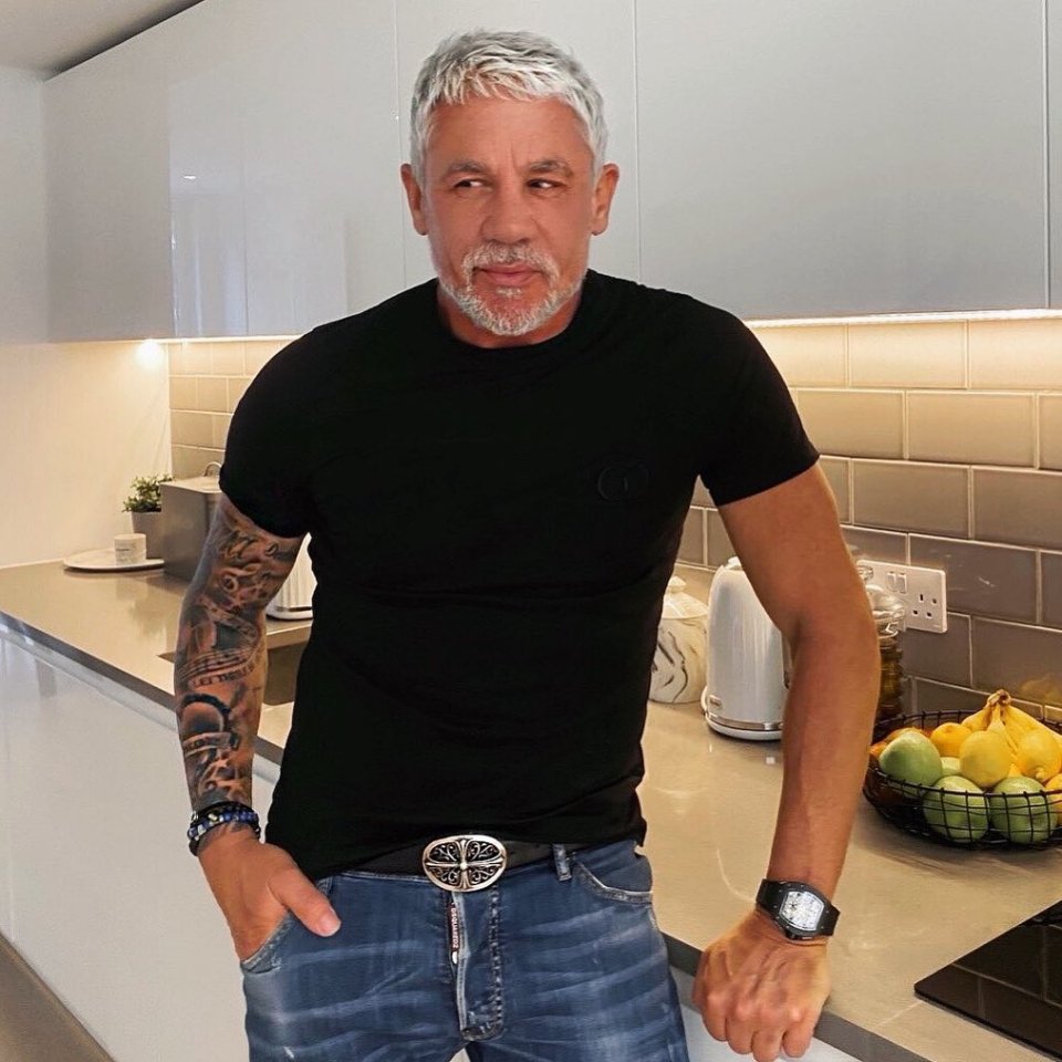 a man wearing a c.p. company shirt sits at a table